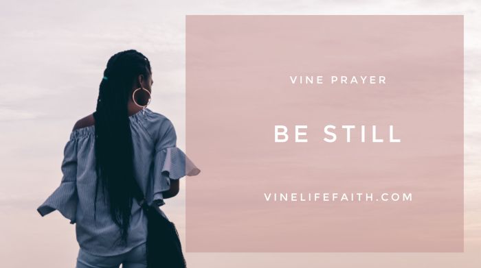 Woman of color alone, looking off into the sunset with text vine prayer, be still, vinelifefaith.com.